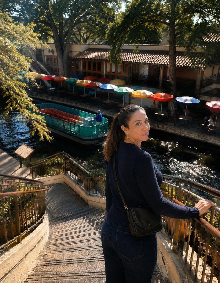 Anna beside a riverside walkway and colourful boats